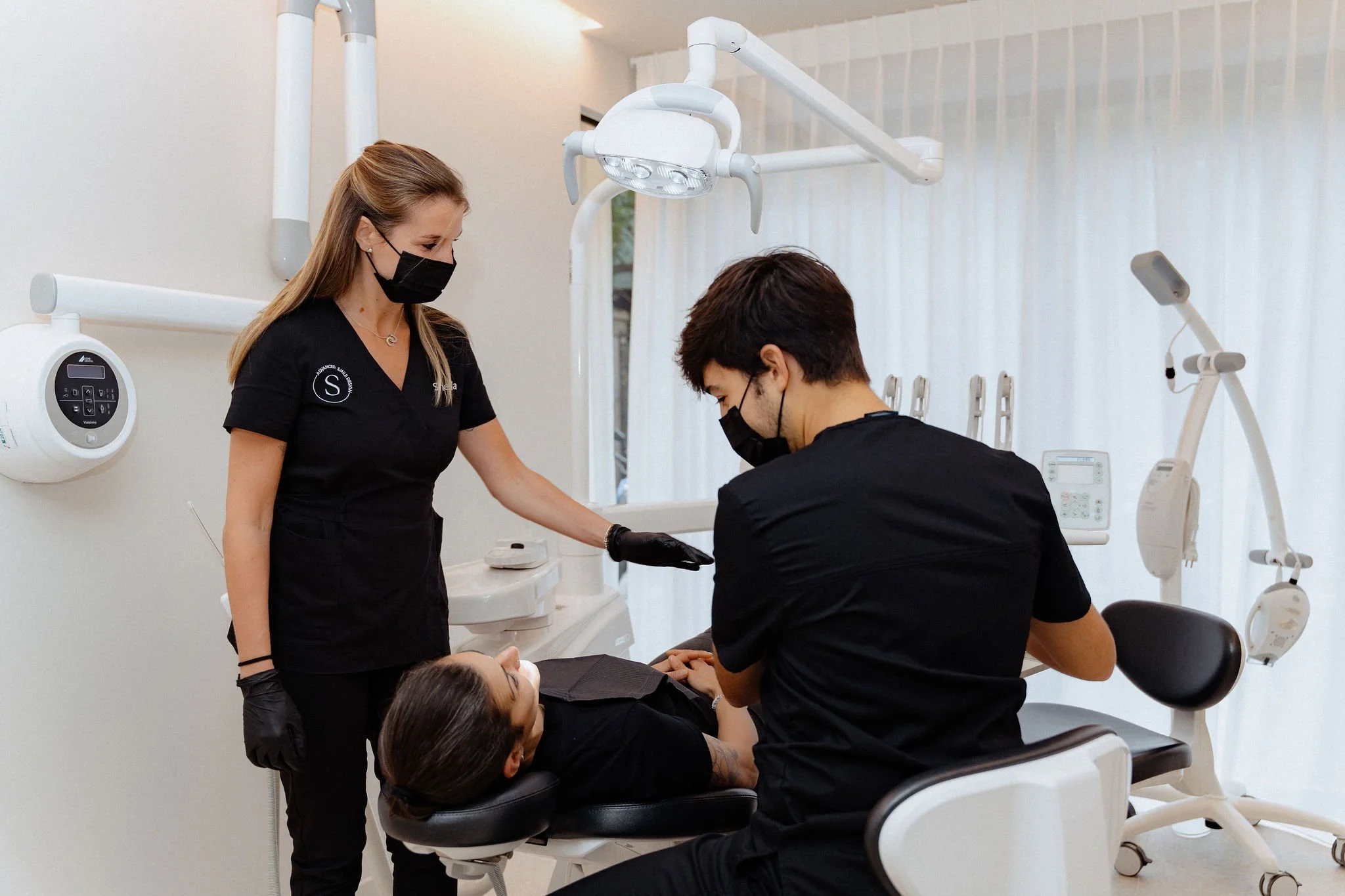 Smitasmile dentist performing dental procedure on patient in Barcelona clinic with modern computer monitors, advanced equipment, demonstrating conscious dentistry approach